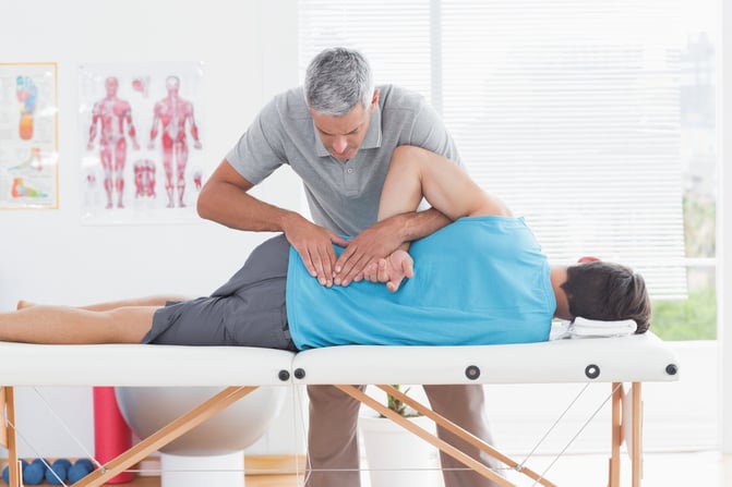 Doctor examining man back in medical office